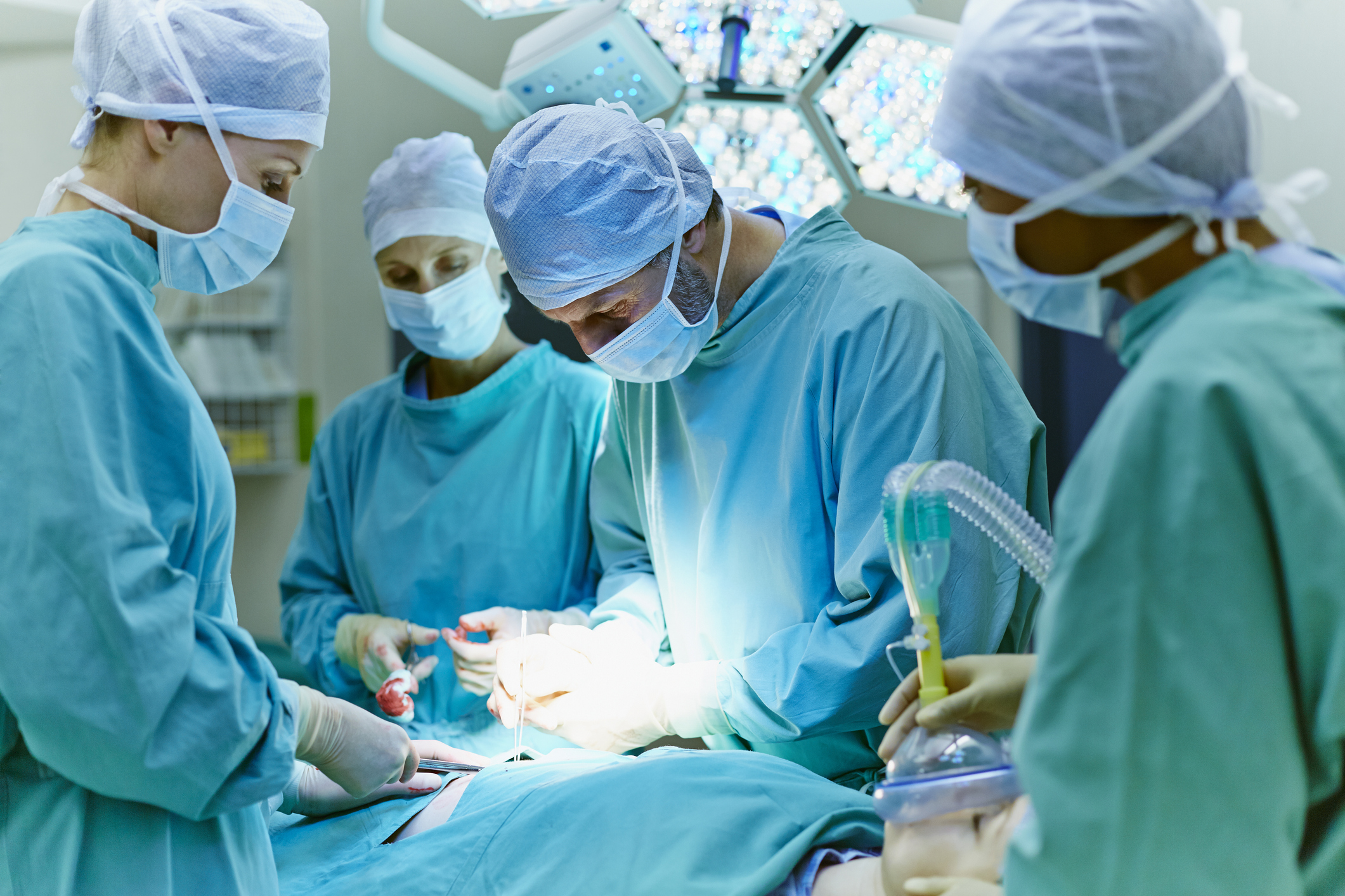 Group of surgeons performing surgery on patient in operating room