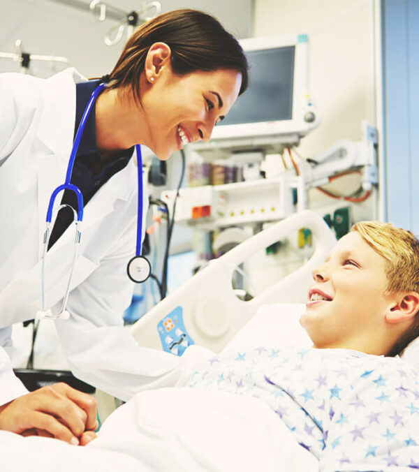 Happy Young Girl Talking To Smiling Female Doctor In Intensive Care Unit