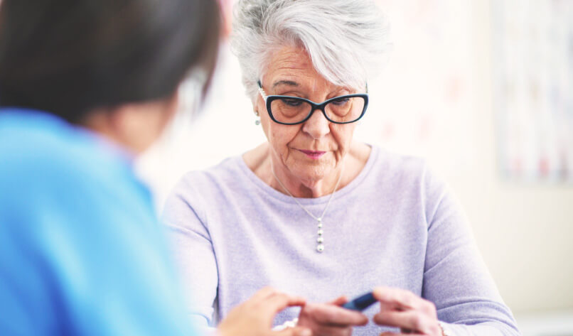 A senior woman talks to her doctor about some recent struggles she is going through. She looks a little distraught.