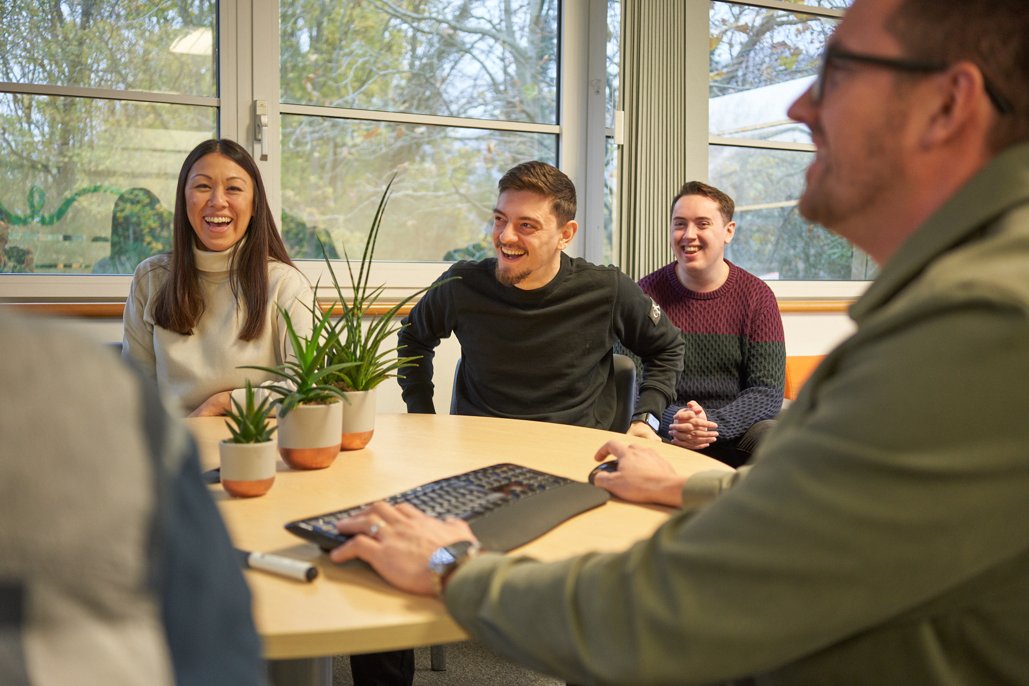 Happy colleagues at the ID Medical office converse and laugh during a friendly meeting