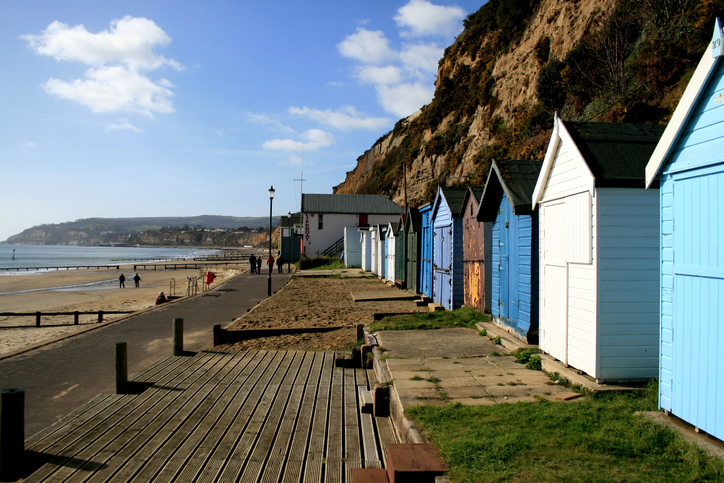 A row of several beach huts at Shanklin Sea front on the Isle of Wight, it is a bright and warm day