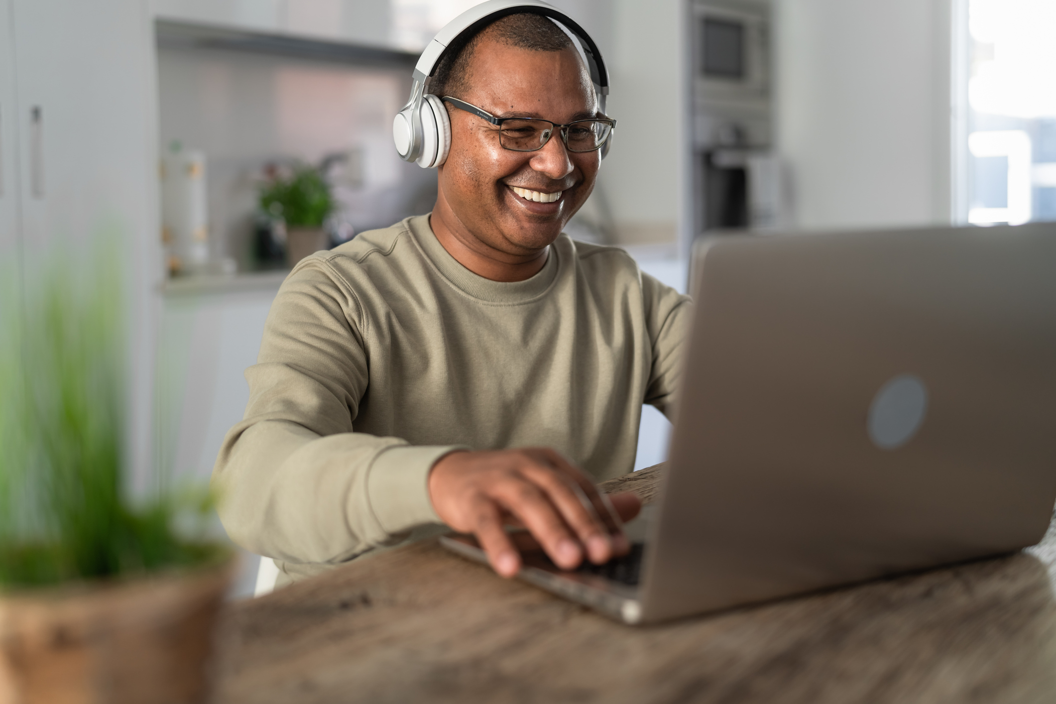 Happy senior man having fun doing using laptop at home