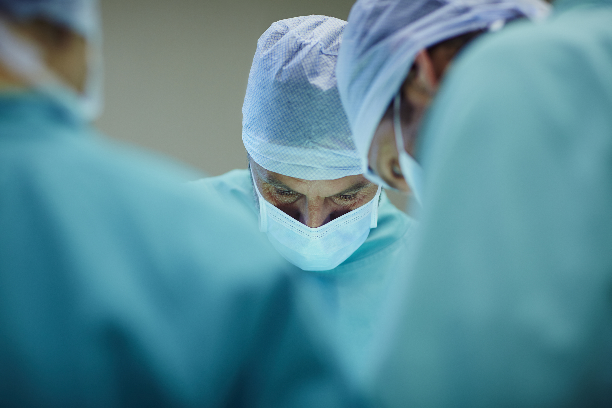 Masked healthcare professionals performing surgery on a patient