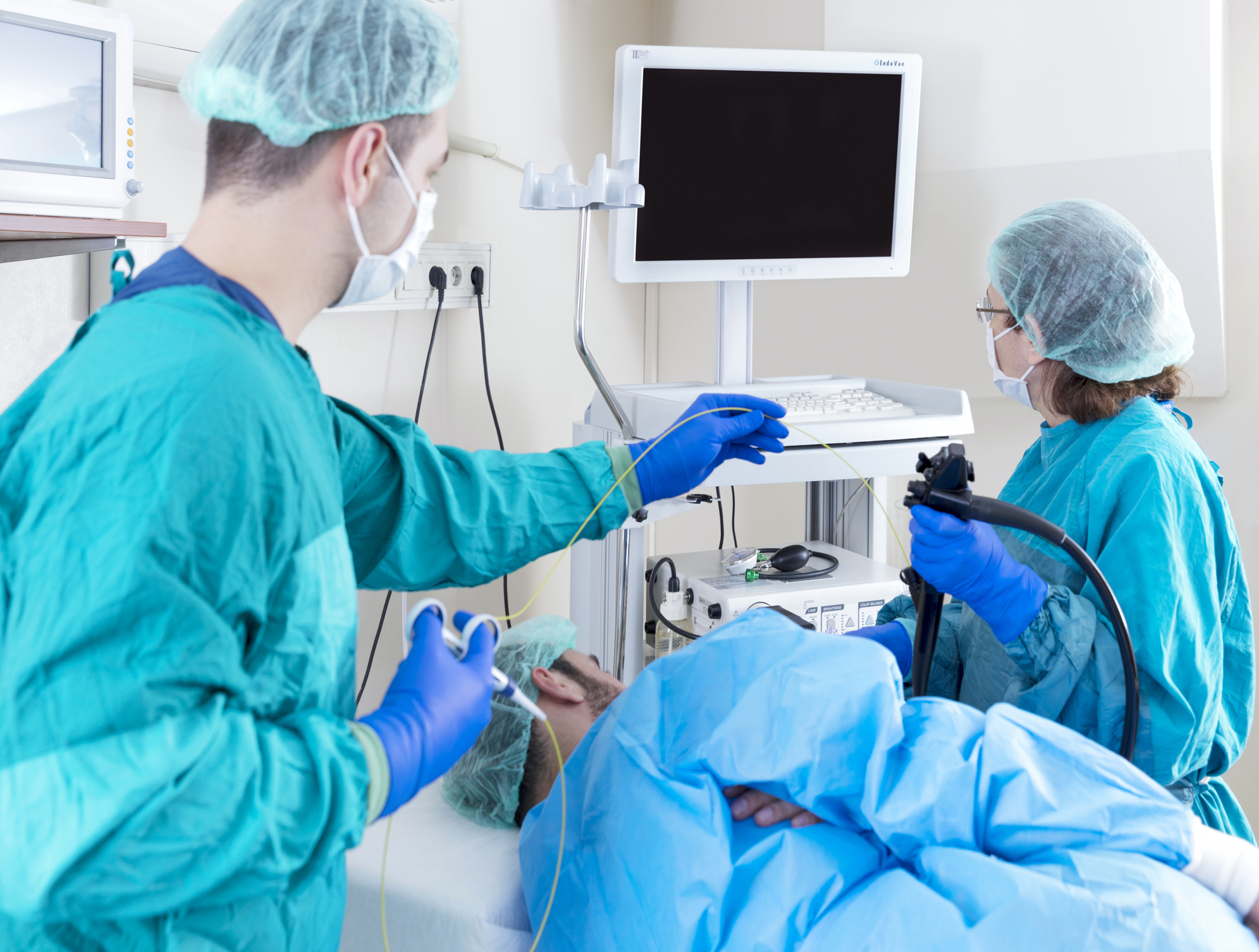 Two healthcare professionals conducting a fiber-optic gastroscopy on a patient