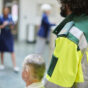 Paramedic bringing patient to hospital in a wheel chair through a busy lobby