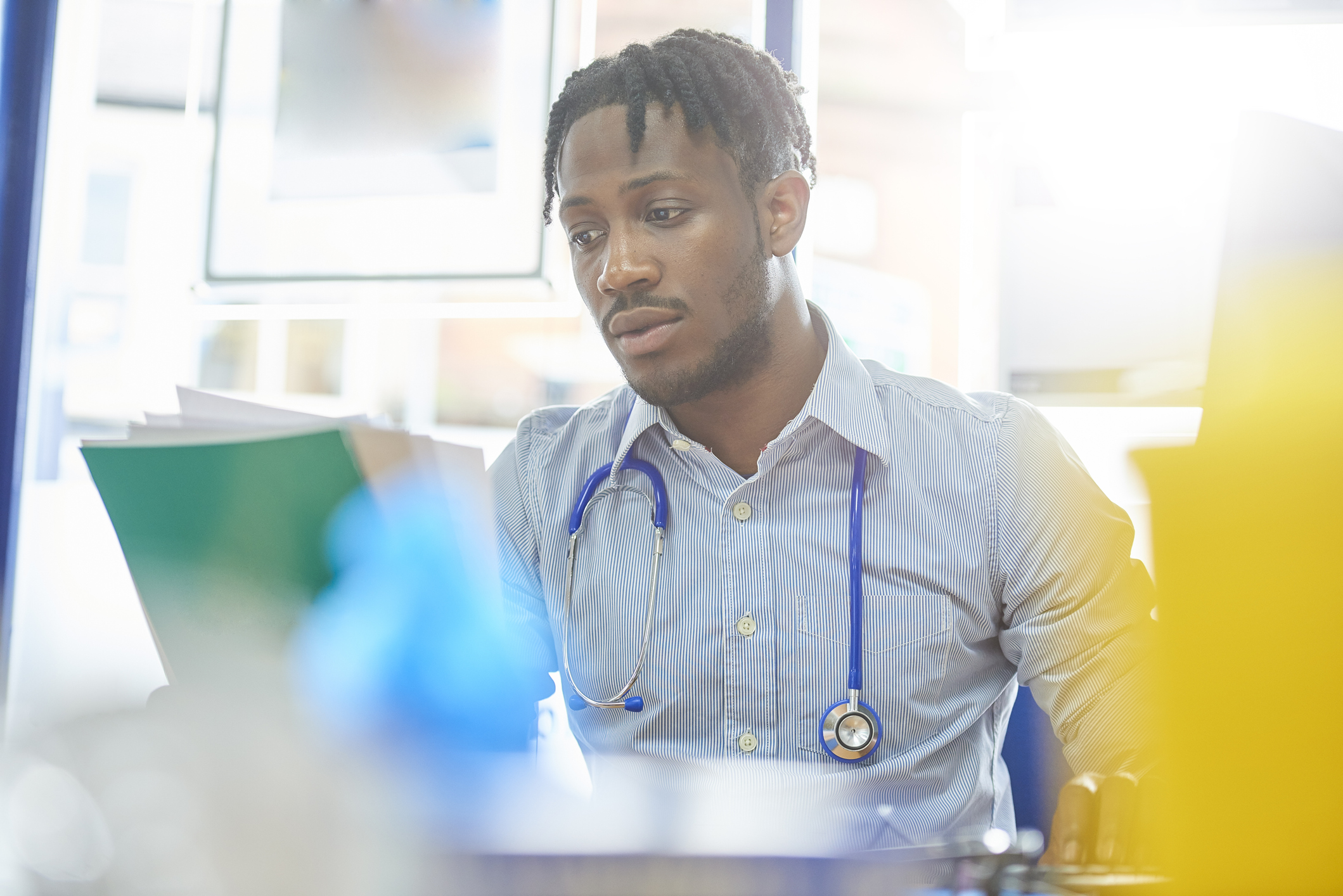 Male doctor looking at file notes