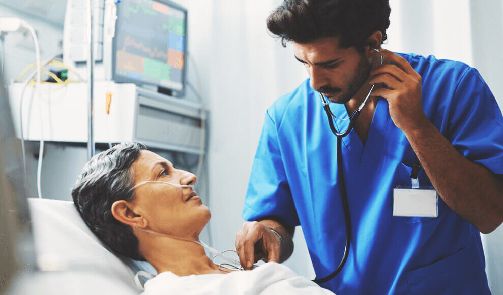 Doctor listening to patient's chest in hospital