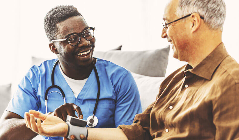 Smiling doctor holding patient's wrist for assessment