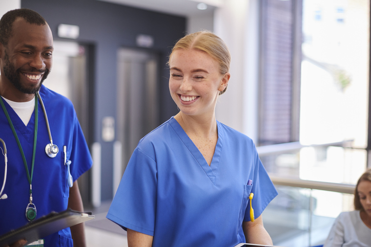 Cheerful medical team walking along hospital corridor