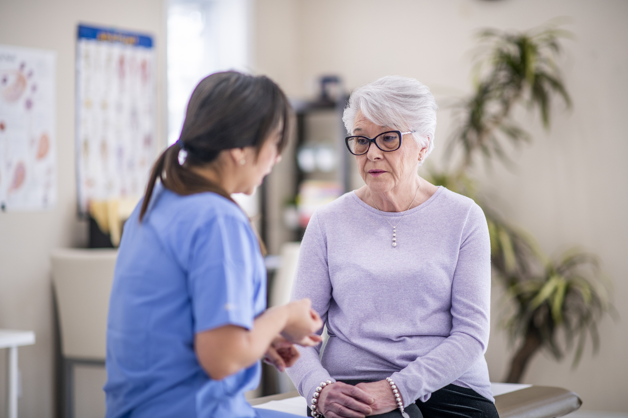 A senior woman talks to her doctor about some recent struggles she is going through. She looks a little distraught.