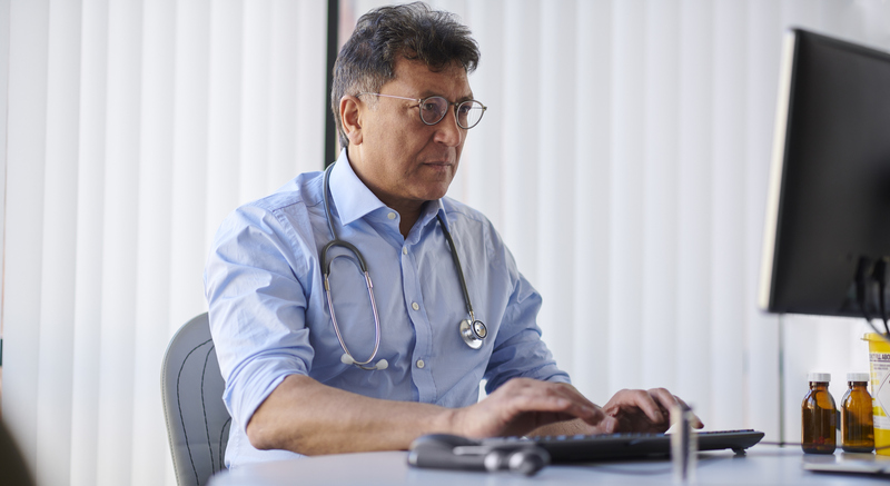 GP on his computer in the office