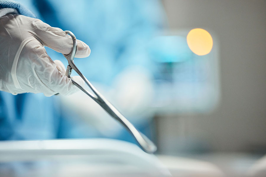 Closeup of surgical clamps in a surgeons hands during an operation