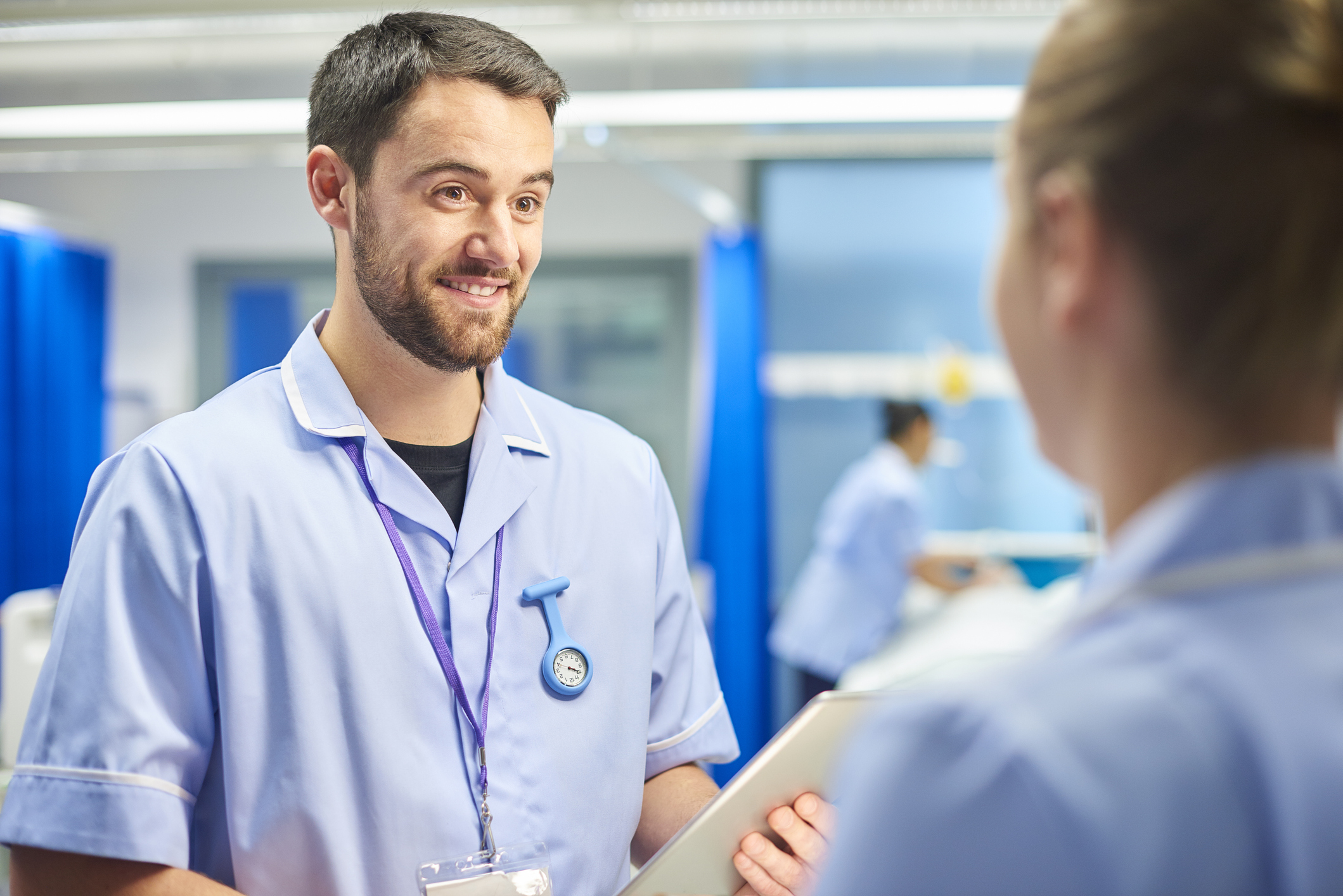 Male and female Nurse discussing a case on a hospital ward