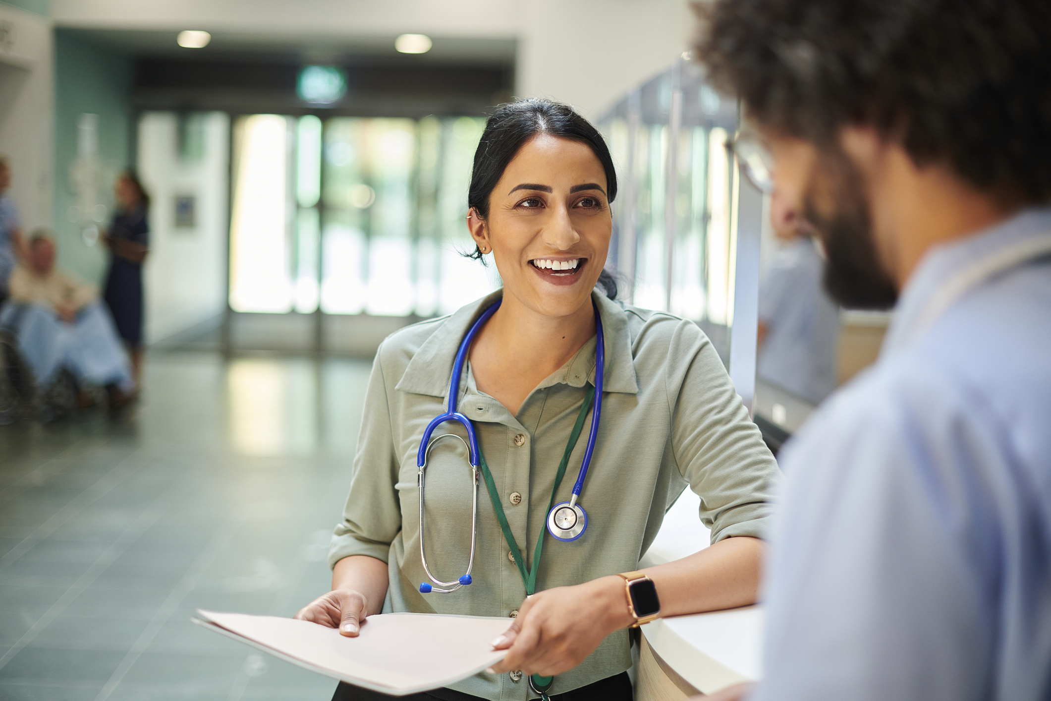 Hospital Doctor chatting to nurse in a hospital lobby