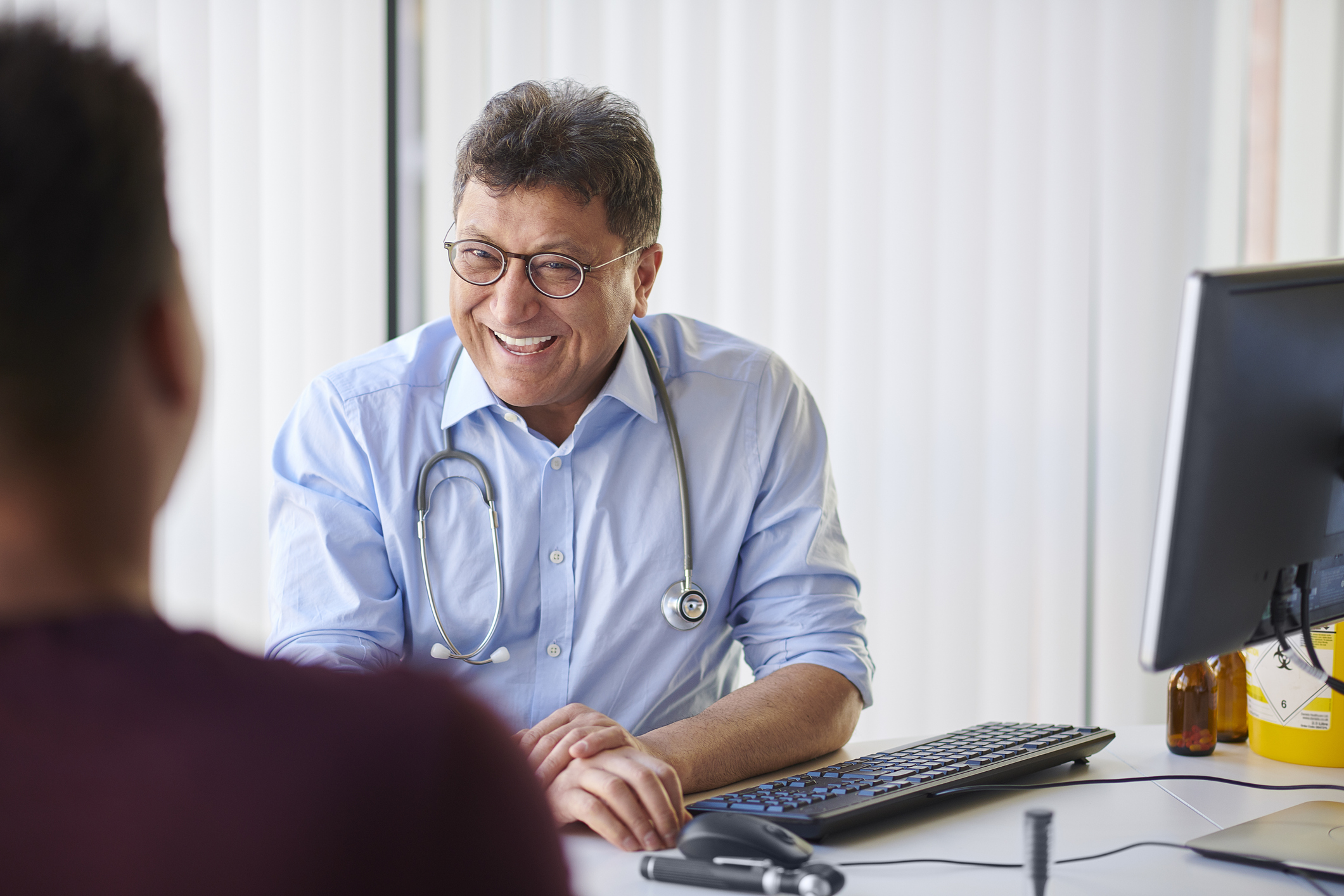 General Practitioner laughing with patient in office