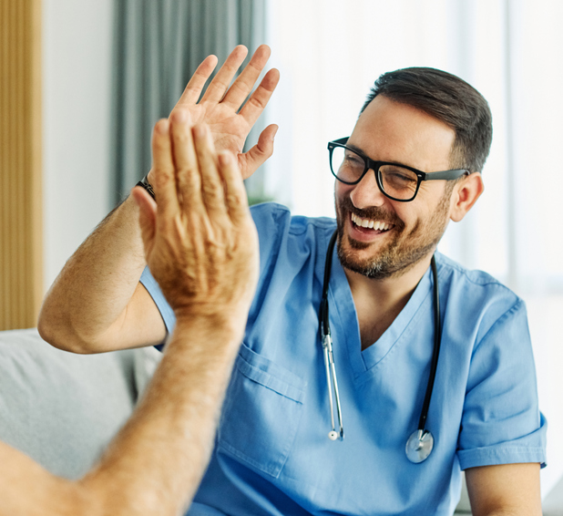 Caregiver with senior patient smiling giving a high five