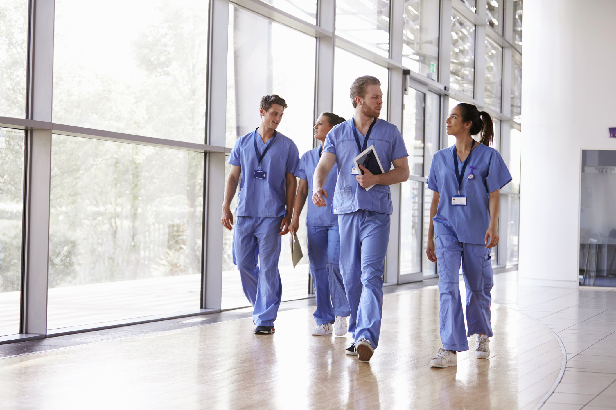 Group of Nurses walking down a hospital corridor discussing work